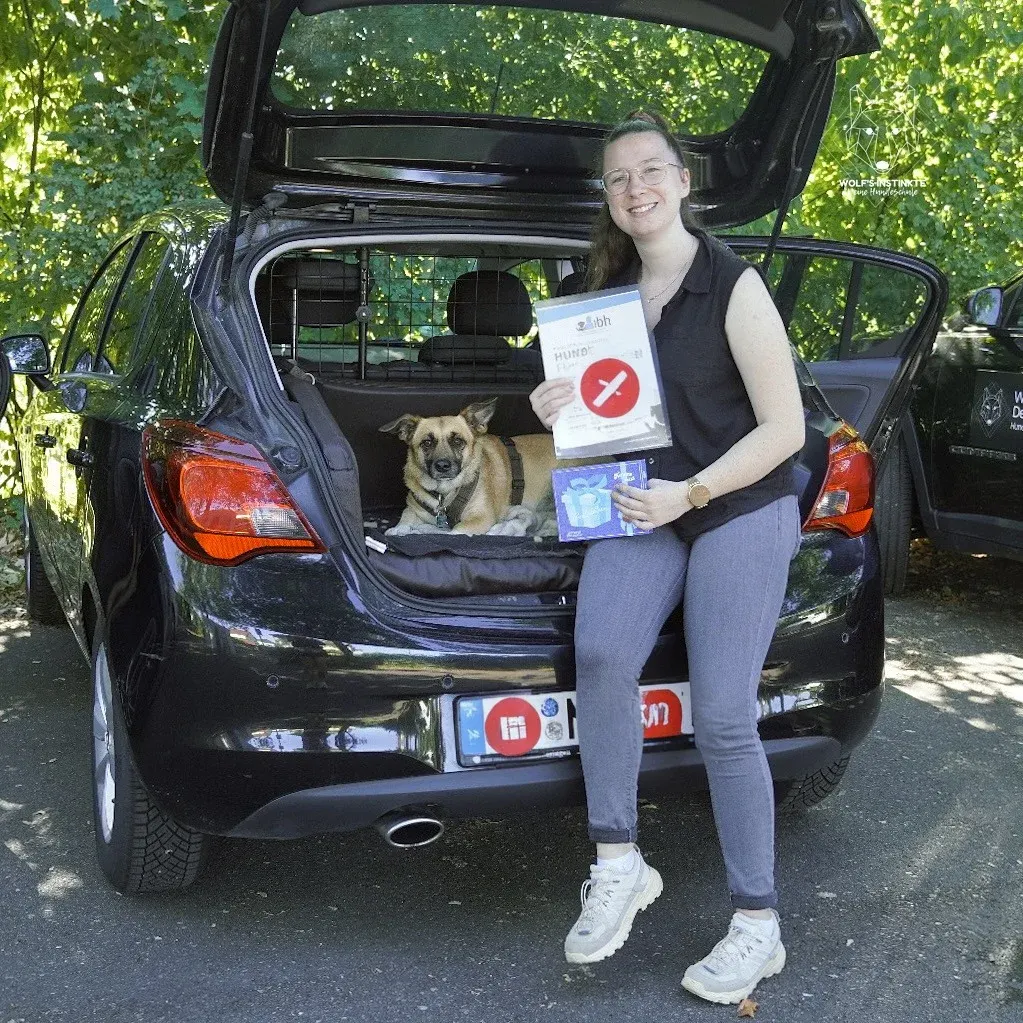 Teilnehmerin mit Hund und Urkunde nach der Hundeführerscheinprüfung